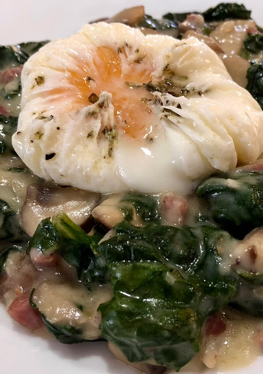 Una foto de Espinacas a la crema con champiñones, jamón y huevo poché