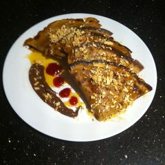 A picture of Crumpet with chocolate, strawberry jam, syrup and chopped almonds !.