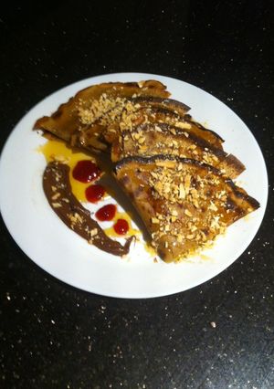 A picture of Crumpet with chocolate, strawberry jam, syrup and chopped almonds !.
