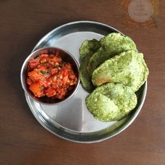 A picture of Palak-Methi Poori with tomato chutney.
