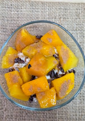 Una foto de Postrecito tibio de mango y nibs de cacao sobre ricota entera 🥭De invierno con toque tropical 🍹