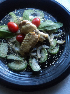 Una foto de Ensalada de tomatillo de milpa verde, cebolla, amaranto, chía, epazote, tomate cherry y alitas