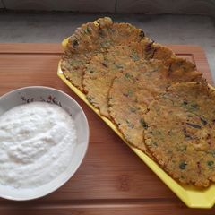 Jowari methi pyaaz rotla with curd A picture of Jowari methi pyaaz rotla with curd.