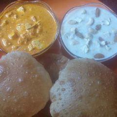 A picture of Thali with puri,paneer sabji and kheer.
