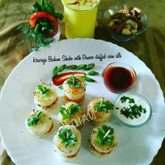 A picture of Kesariya Badam Shake with Paneer Stuffed coin idli.