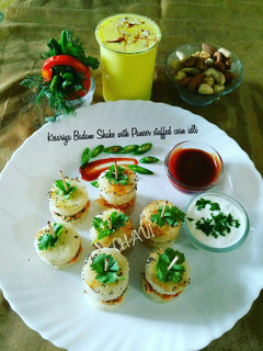 A picture of Kesariya Badam Shake with Paneer Stuffed coin idli.