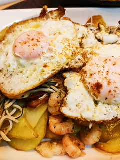 Una foto de Anguriñas con gambas y huevo con base de patatas al ajo cabañil