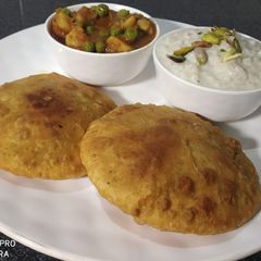 A picture of Hare matar ki puri with aloo matar ki sabji & rice kheer.