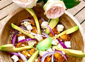 Une photo de Salade de quinoa à la patate douce rôtie au miel, avocat, feta, oignons rouges et pignons