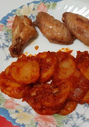 Foto principal de Alitas de pollo fritas acompañadas de patatas con tomate