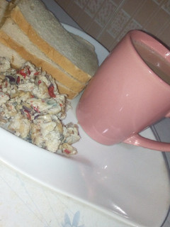 A picture of Masala tea and scrambled egg with sardines.