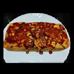 A picture of Apple walnuts cake with dry fruits caramel crust.