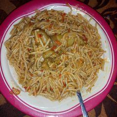 A picture of Jollof spaghetti with chicken.