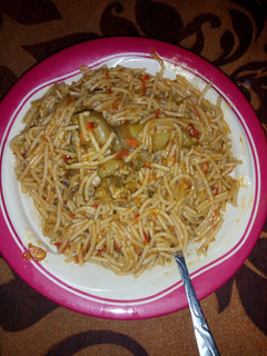A picture of Jollof spaghetti with chicken.