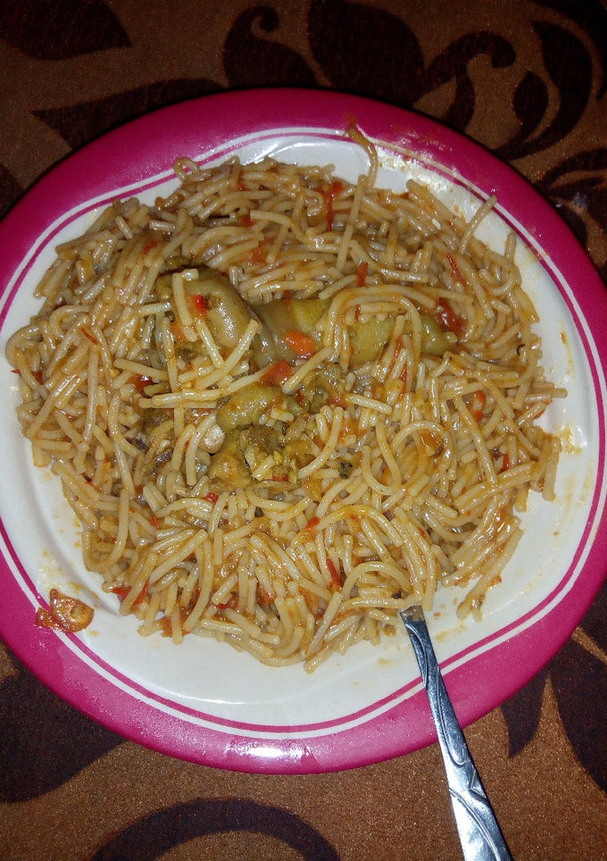 A picture of Jollof spaghetti with chicken.