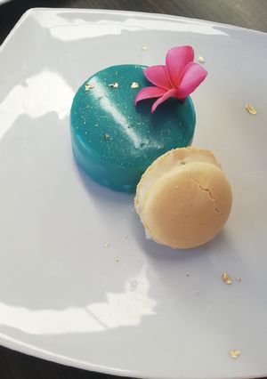 Una foto de Mousse con glaseado espejo y jelly decorado con macarrones