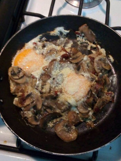 Una foto de Huevos fritos con champiñones al ajillo y queso parmesano