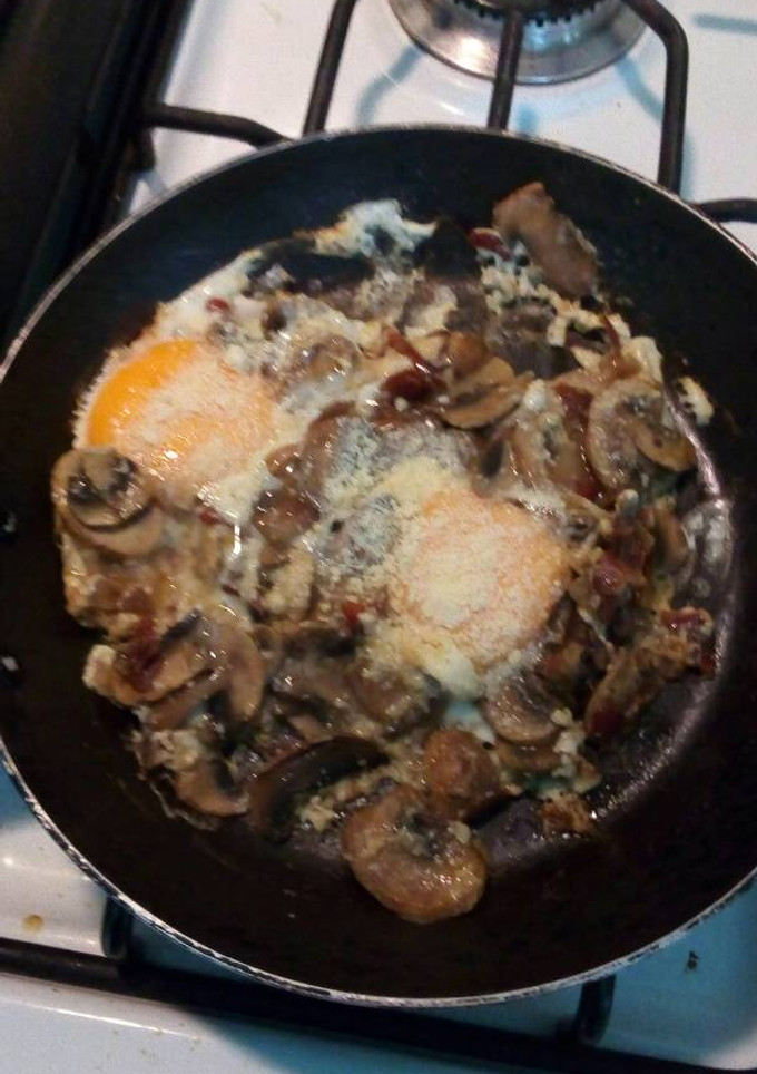 Una foto de Huevos fritos con champiñones al ajillo y queso parmesano