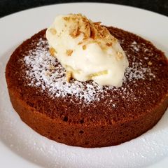 A picture of Chocolate cake topped w homemade custard ice cream.