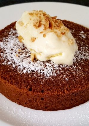 A picture of Chocolate cake topped w homemade custard ice cream.