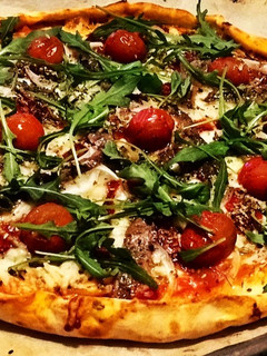 Una foto de Pizza casera de rucula y anchoas