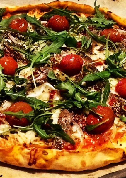 Una foto de Pizza casera de rucula y anchoas