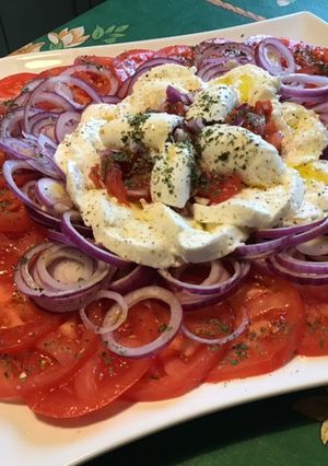 Une photo de Salade de tomates roses aux oignons rouges et mozzarella di buffala