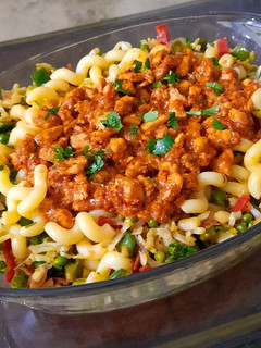 A picture of Pasta with red chicken sauce and vegetables.