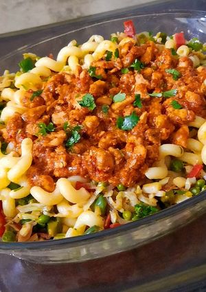 A picture of Pasta with red chicken sauce and vegetables.