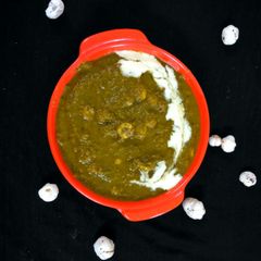 A picture of Makhana lotus seeds with potato in Spinach greavy.