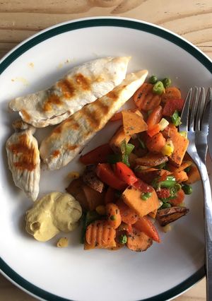A picture of Grilled chicken with fried sweet potato and veggies.