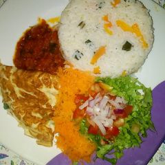 A picture of Carrot rice with stew, fried egg and lettuce salad.