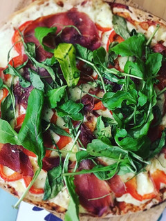 Una foto de Pizza de jamón serrano y rúcula
