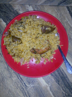 A picture of Jollof rice wt pomo n slice onion.