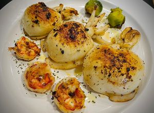 Una foto de Sepia a la plancha con gamba roja y coles de Bruselas