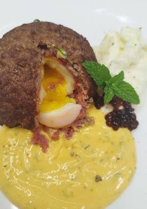 Foto di Polpetta con cuore alla coque, salsa alla zucca, spuma di parmigiano e caviale di aceto balsamico