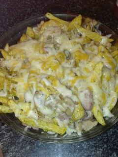 Una foto de Patatas con pechuga de pollo salchichas frescas champiñones aderezadas y gratinada