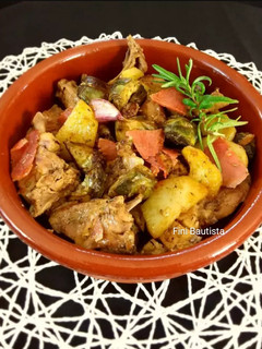 Una foto de Conejo con alcachofas patatas y jamón
