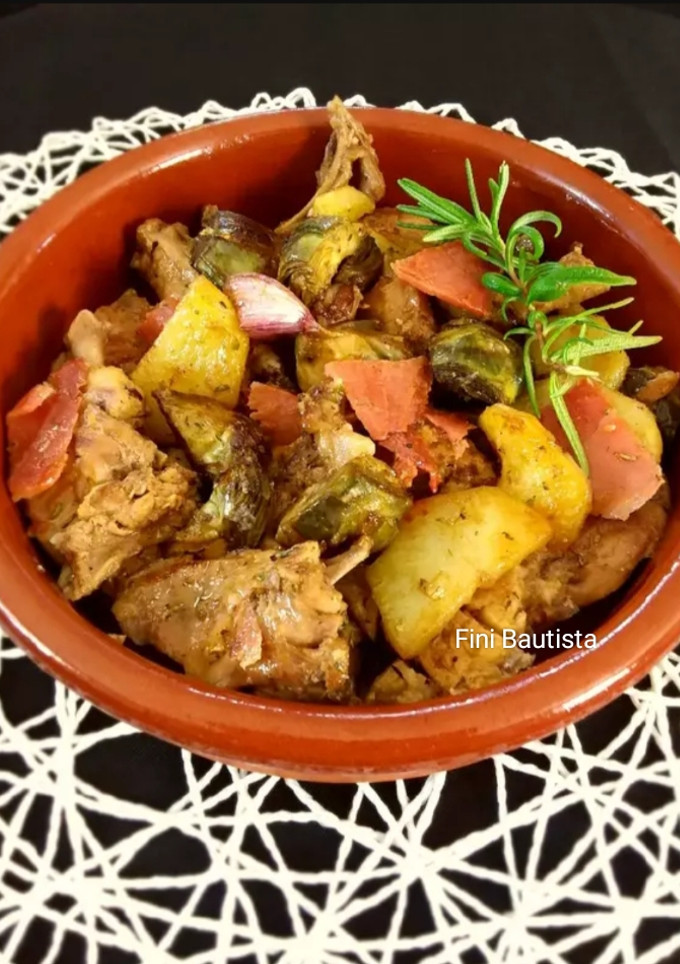 Una foto de Conejo con alcachofas patatas y jamón