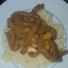 A picture of Creamy peanut sauce with beef strips and cous cous.