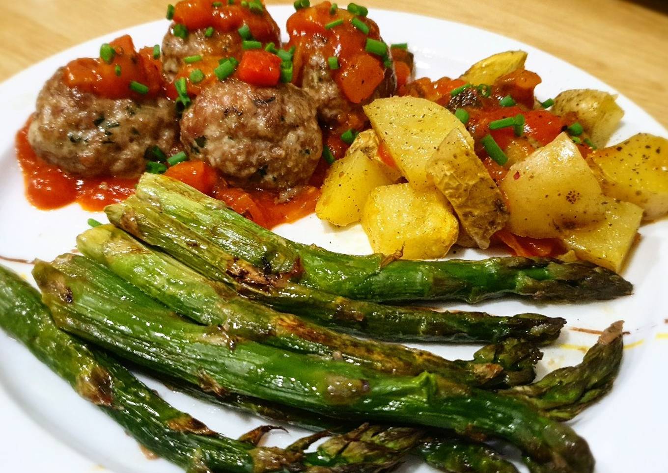 Albóndigas al horno con pisto, espárragos verdes y patatas