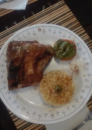 Una foto de Costillas de cerdo en salsa a base de cola y pola, con tomates rellenos de guacamole