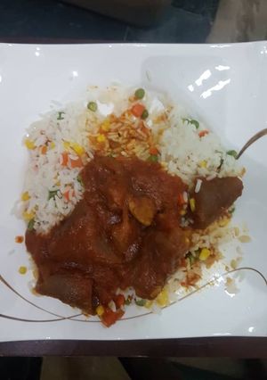 A picture of Stew and boiled rice with mixed vegetables.
