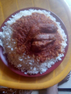 A picture of White rice with stew and fish.