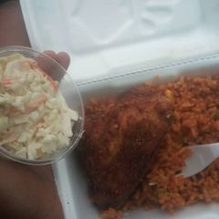 A picture of Jollof rice,fried chicken and coleslaw.