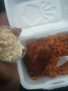A picture of Jollof rice,fried chicken and coleslaw.