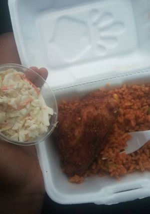 A picture of Jollof rice,fried chicken and coleslaw.