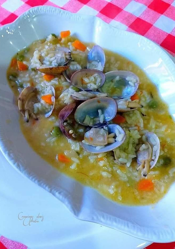 Una foto de Arroz súper caldoso de almejas al azafrán en dos caldos