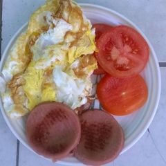 A picture of Fried eggs polony and tomato.