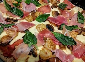 Una foto de Pizza integral con jamón serrano, camarones